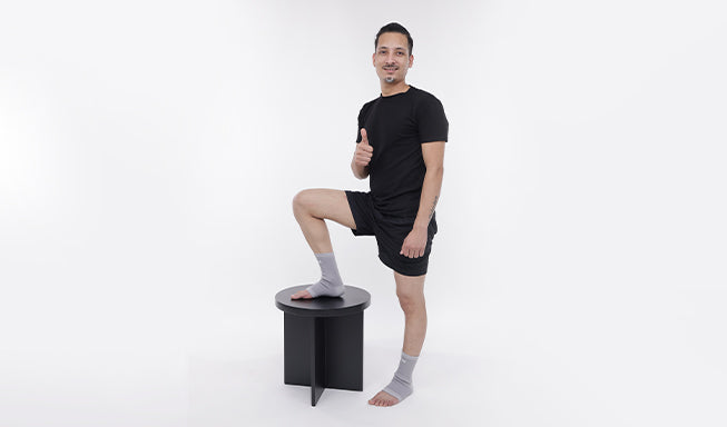 person wear gray ankle support and giving thumbs up