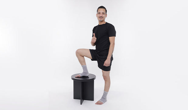 person wear gray ankle support and giving thumbs up