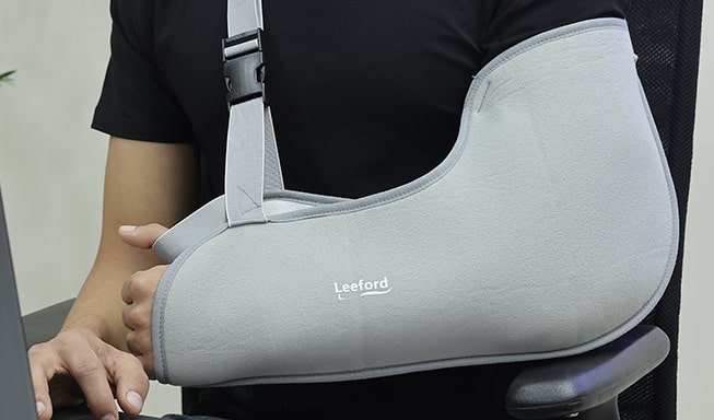 person wear arm sling in left arm with leeford branding