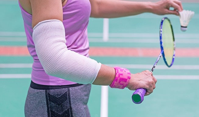 Badminton Player wear Elbow Support in service gaming mode