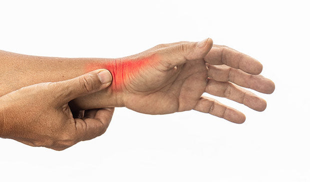 person indicating his wrist suffering from De Quervain’s Syndrome pain