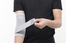 person wearing gray elbow binder with Leeford Branding