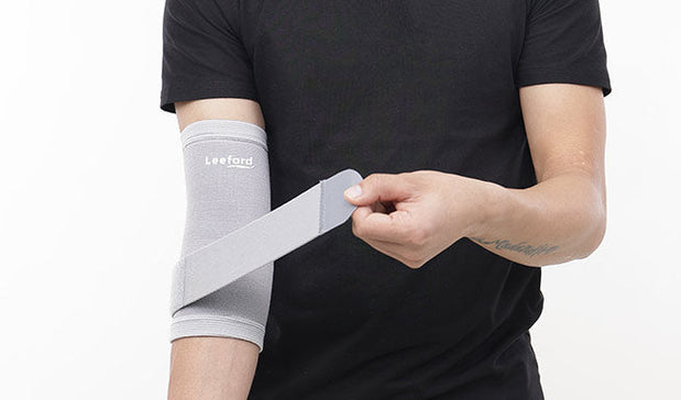 person wearing gray elbow binder with Leeford Branding