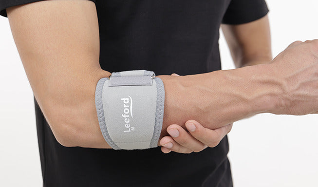 person wear gray tennis elbow support with leeford branding