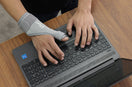 person wear thumb spica splint in his left hand while working on the laptop