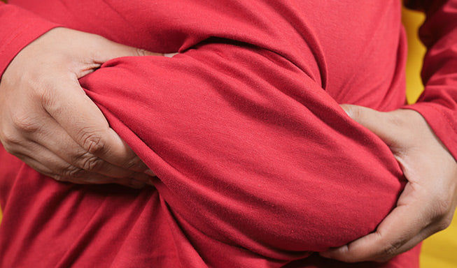 person holding his stomach and feeling umbilical hernia pain