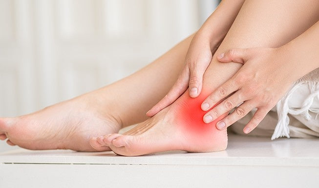 woman hold her ankle in pain