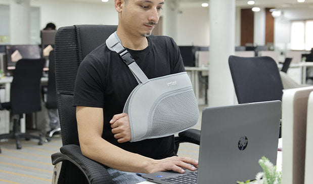 man wear arm support while working on the laptop