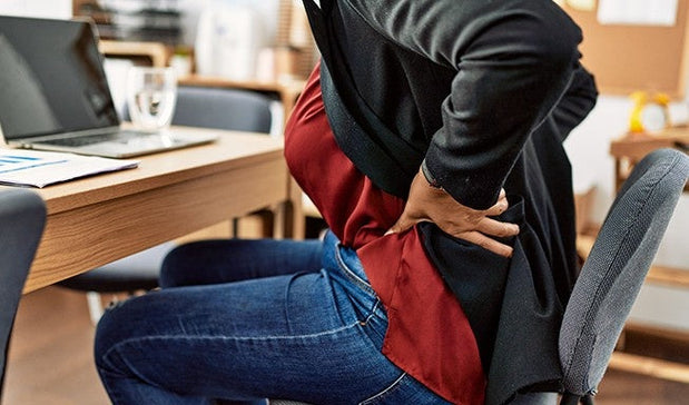 woman facing back pain while working on the laptop