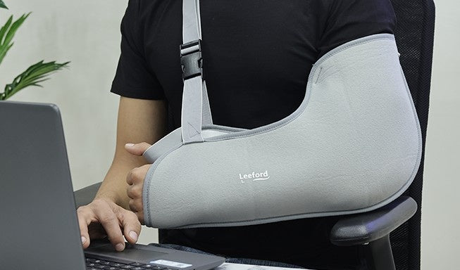 man wear a gray arm sling on his right hand