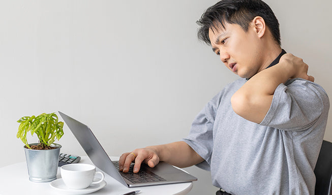 man working on laptop and face shoulder pain