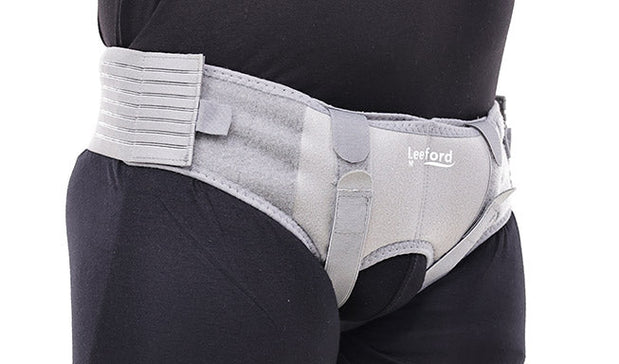 man wear a gray hernia belt with leeford branding on it