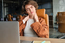 woman suffering with neck pain during working on the laptop