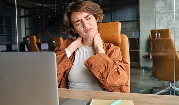 woman suffering with neck pain during working on the laptop
