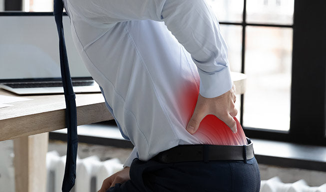 man suffering from Sciatica pain while working