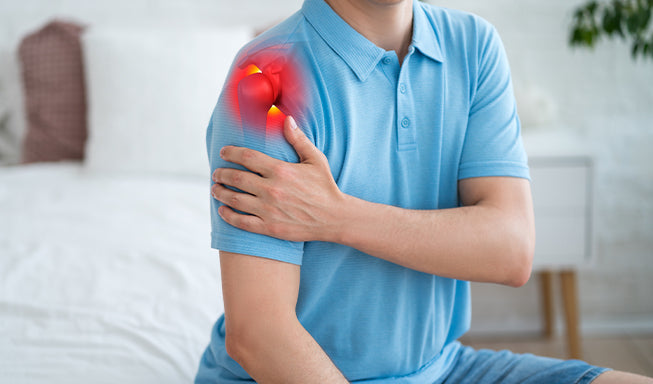 person indicating his left shoulder in pain