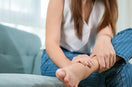 woman hold her left swollen ankle