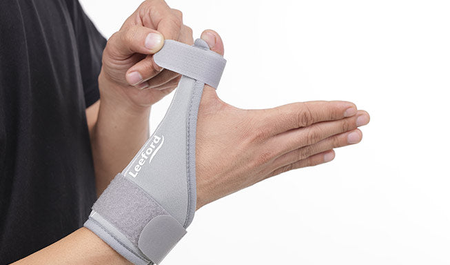person wear thumb support splint gray