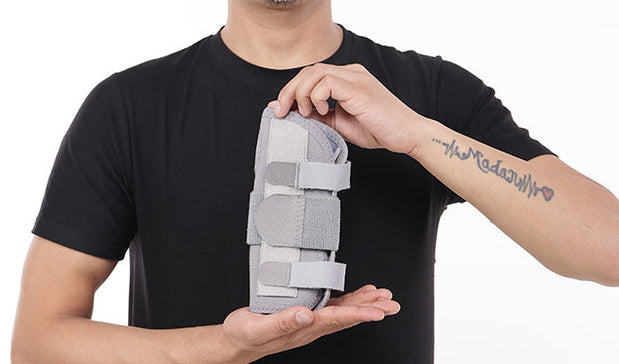 man hold a gray wrist forearm brace