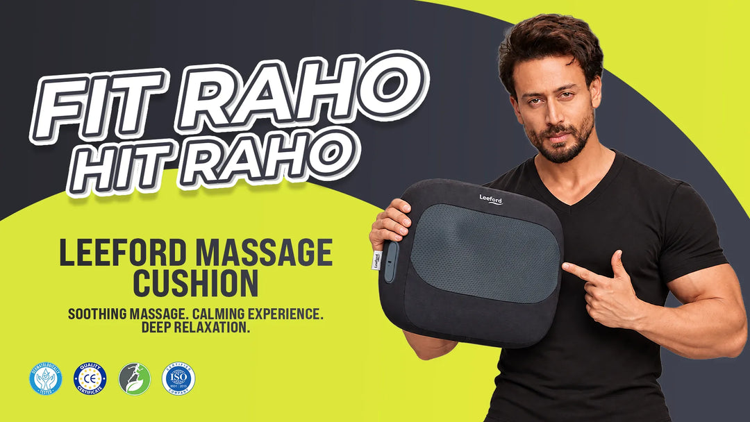 a man in a black t-shirt holds a black and gray Leeford massage cushion