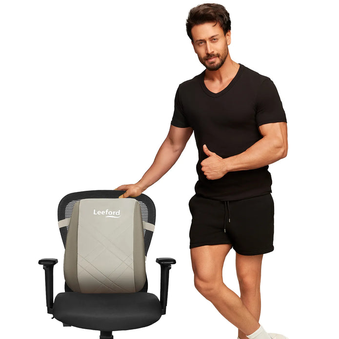 Man standing next to a gray office chair with leeford back rest