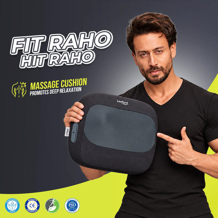 a man in a black t-shirt holds a black and gray rectangular massage cushion